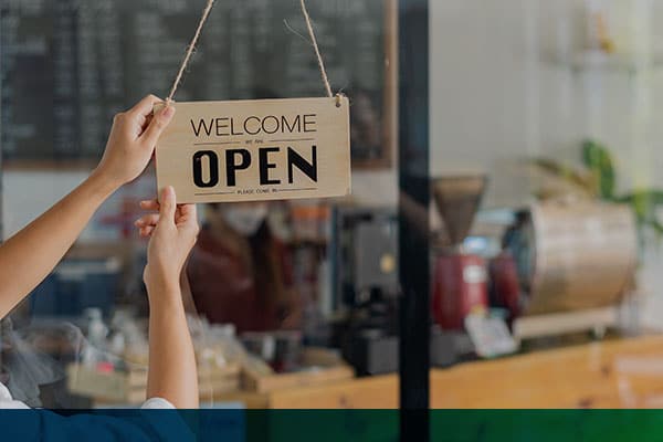 Business owner turning an open sign in a Coffee Shop